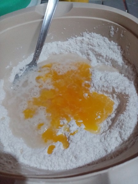 adding yeast, egg, & melted butter to flour