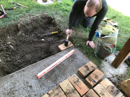 Placing the first brick in the patio.