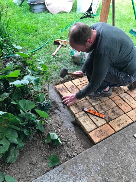 Placing the final brick into the patio.
