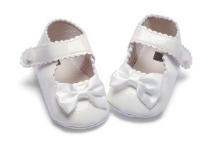 A white pair of baby shoes.