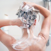 A woman washing her hair in the shower.