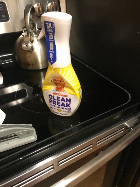 A bottle of cleaner on a stove.