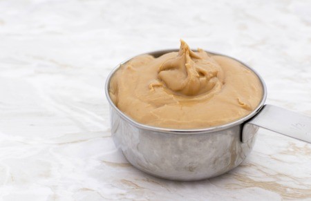 A measuring cup of peanut butter.