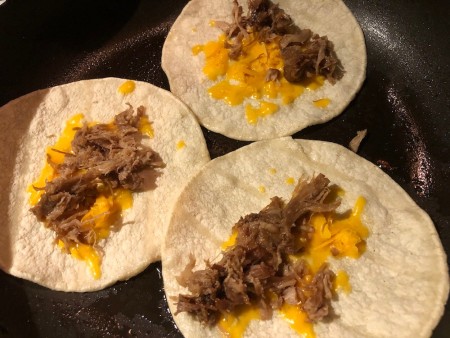 filling tortilla with corn mixture & meat