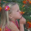 A girl smelling a colorful flower.