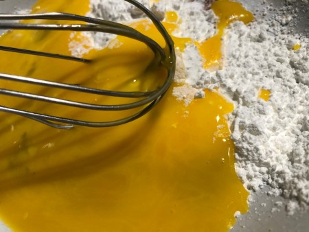 adding eggs to flour