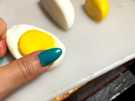 Gravity-Defying Ramen Cake - pressing yellow fondant onto white half boiled egg shape