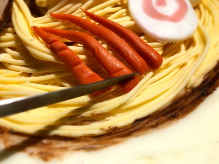 Gravity-Defying Ramen Cake - carrots on top of noodled, being scored with a knife