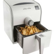 An electric air fryer with French fries.
