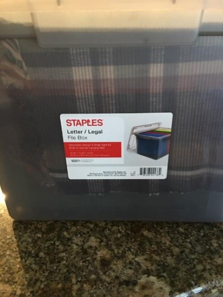 A plastic file box filled with placemats.