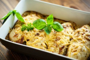 A casserole baking dish filled with chicken and cheese.