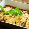 A casserole baking dish filled with chicken and cheese.
