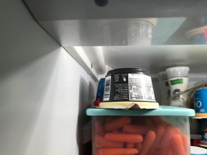Upside down container of yogurt in the fridge