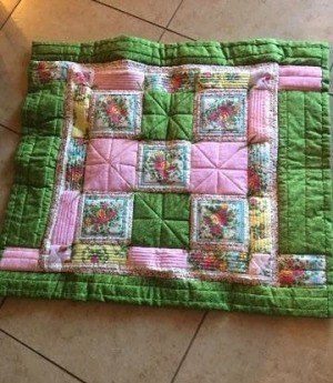 I Never Promised You a Rose Garden (Quilt) - finished quilt on a tile floor