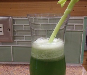 Celery stalk in glass of celery Juice