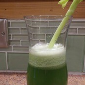 Celery stalk in glass of celery Juice