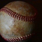 An old baseball on a black background.