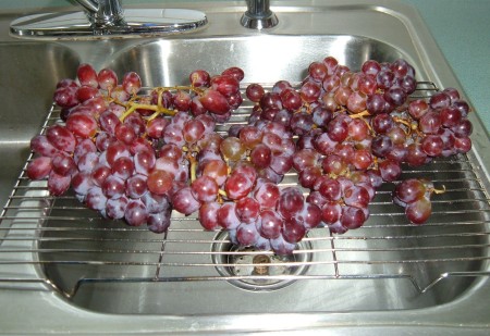 A cooling rack being used to drip dry grapes.