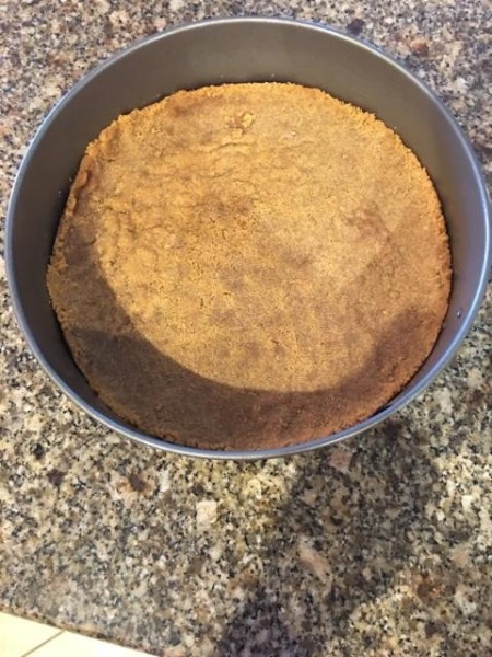 A graham cracker crust in a baking pan.