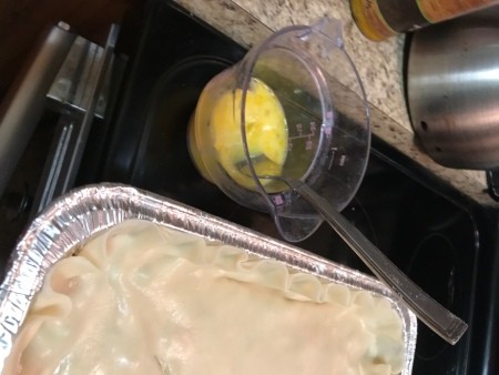 adding pie dough top to pan