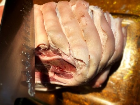 Cutting slits into the pork roast.