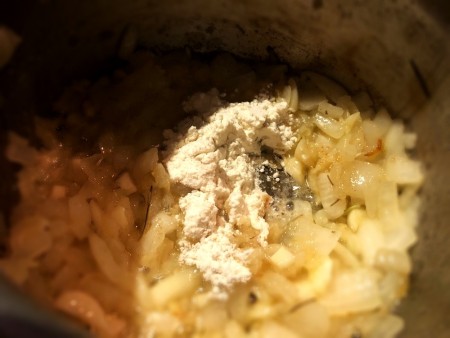 Flour being added to the onion mixture.