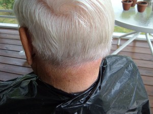 A trash bag being used as a cape for cutting hair.