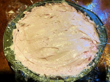 Filling the cake pan with strawberry ice cream.