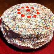 The strawberry ice cream cake decorated with hearts and sprinkles.