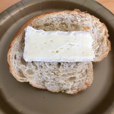 A piece of bread topped with a slice of brie.