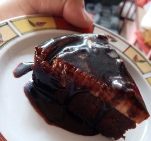 A piece of glazed custard chocolate cake.