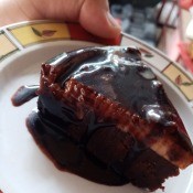 A piece of glazed custard chocolate cake.