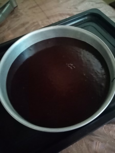 Chocolate cake batter in a cake pan.