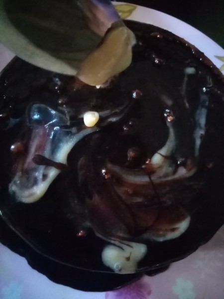 Covering the cake with a chocolate caramel glaze.