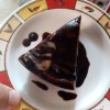 A piece of glazed custard chocolate cake.