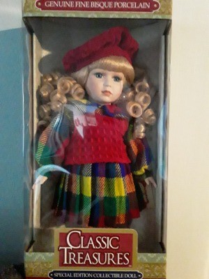 Value of a Classic Treasures Porcelain Doll - blond haired doll wearing a red beret, red sweater vest over a long sleeve plaid dress