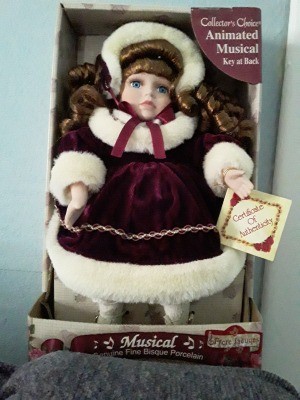 Value of a Collector's Choice Musical Porcelain Doll - doll wearing a white faux fur trimmed coat and hat