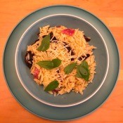 A dish of orzo tossed with sun-dried tomatoes, salami and parmesan.