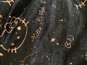 Foil Decorations on Girls' Dresses Falling Off - closeup of a Hello Kitty dress with the gold foil decorations falling off