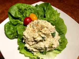 A serving of chicken potato egg salad on a lettuce leaf.