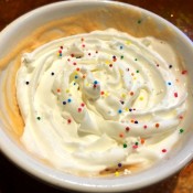 Finished mug cake topped with sprinkles and whipped cream.