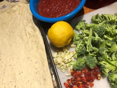 Ingredients for making roasted lemon broccoli pizza.