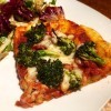 A slice of pizza with salad on plate