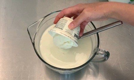 Adding yogurt with live cultures to the mixture.