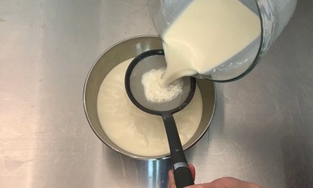 Straining the mixture into a sauce pan.