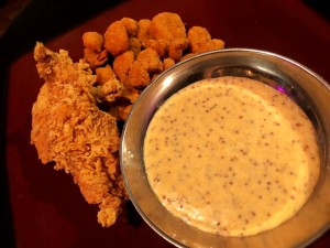 Spicy mustard dipping sauce next to fried foods.