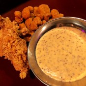 Spicy mustard dipping sauce next to fried foods.