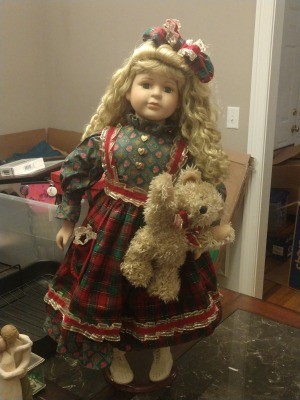 Value of a Collector's Choice Porcelain Doll? - doll wearing a print dress with a plaid apron and holding a teddy bear