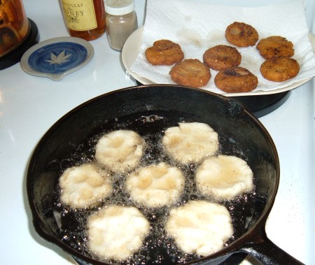 Frying cornbread in batches in a cast iron pan.