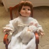 Identifying a Porcelain Doll? - doll in a rocking chair holding a stuffed bunny